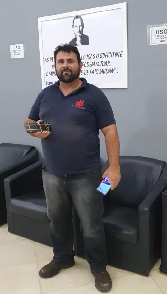 Cliente de camisa polo com o celular na loja iPlanet de São Caetano do Sul